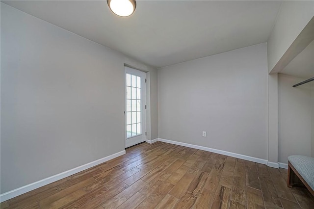 spare room with hardwood / wood-style floors and baseboards
