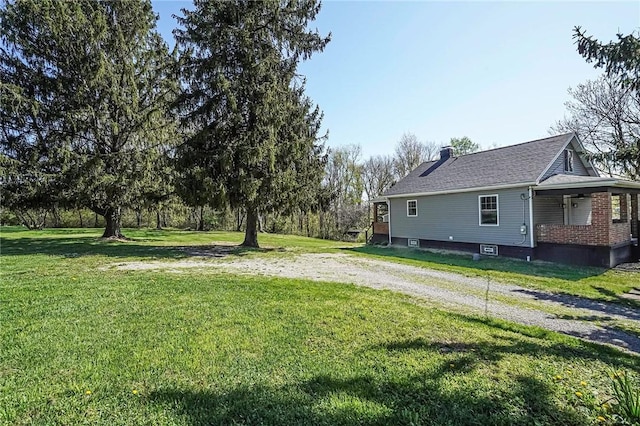 view of yard with driveway and covered porch