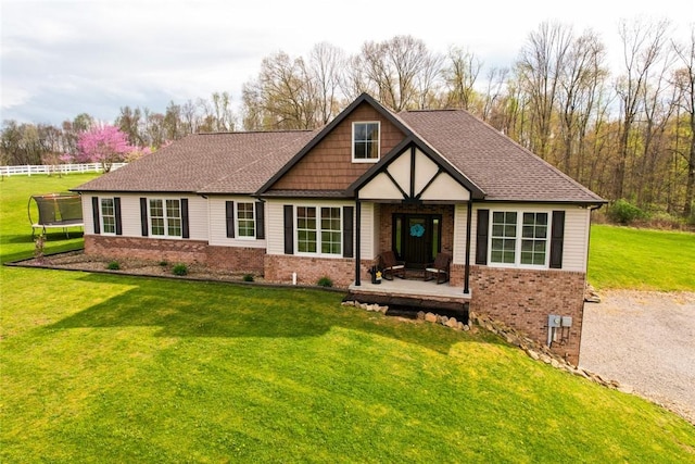 109 Brianna Ln, Oakland Twp, PA 16025 - craftsman-style house featuring roof with shingles, a front lawn, brick siding, and a trampoline