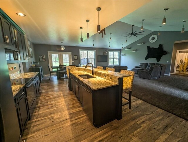 109 Brianna Ln, Oakland Twp, PA 16025 - kitchen with range with electric cooktop, a sink, a breakfast bar, light stone countertops, and dark wood-type flooring