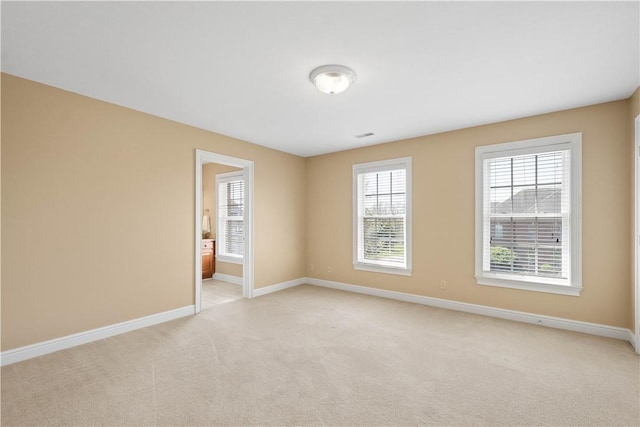 empty room with light colored carpet and baseboards