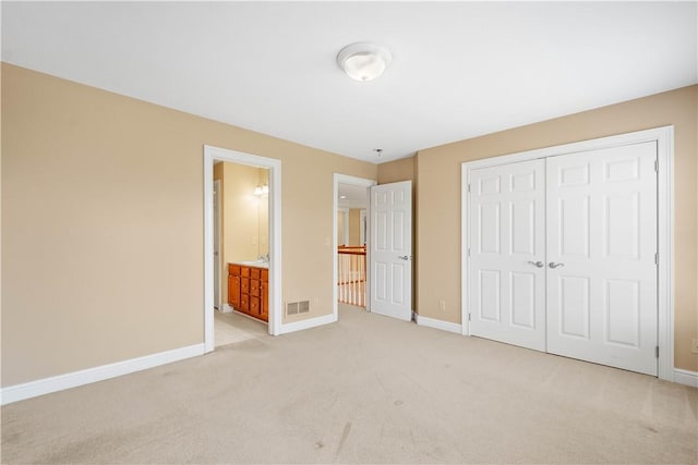 unfurnished bedroom with light colored carpet, visible vents, a closet, and baseboards