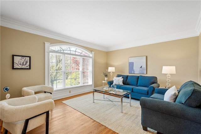 living room with baseboards, ornamental molding, and light wood-style flooring