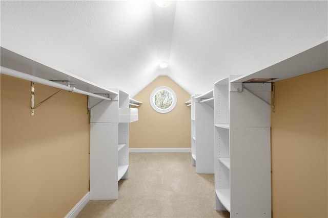 walk in closet with lofted ceiling and carpet flooring