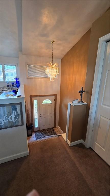 carpeted entryway with a notable chandelier and baseboards