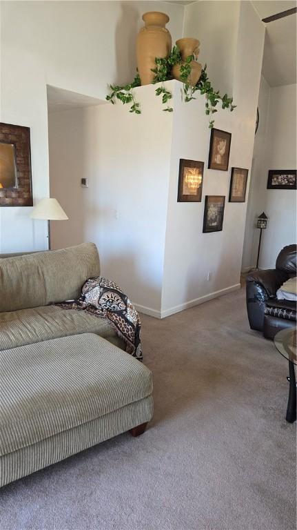 carpeted living area with baseboards