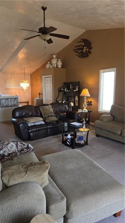 carpeted living area with baseboards, vaulted ceiling, and ceiling fan with notable chandelier