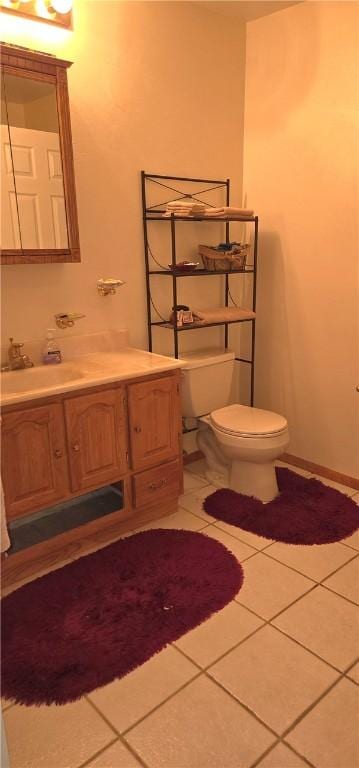 half bathroom with vanity, toilet, and tile patterned flooring