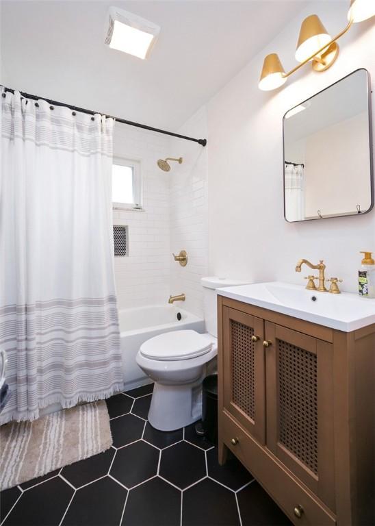 bathroom featuring toilet, shower / bath combo, and vanity