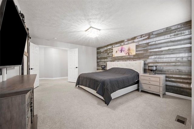 bedroom with baseboards, visible vents, a textured ceiling, and carpet flooring