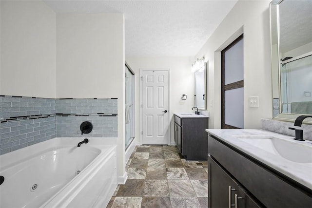 bathroom featuring a tub with jets, a shower stall, and a sink