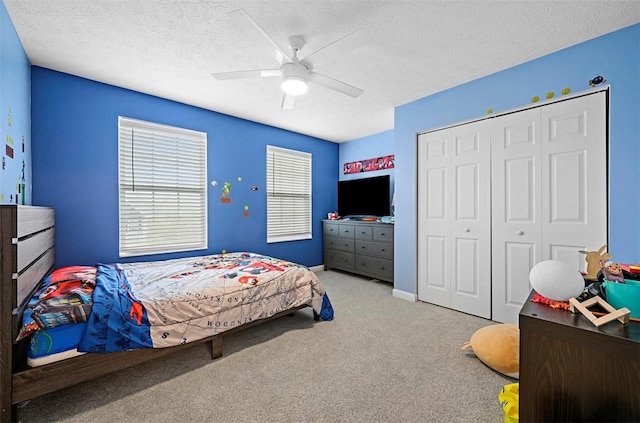 bedroom featuring a closet, carpet flooring, ceiling fan, and a textured ceiling