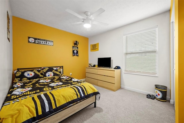 carpeted bedroom featuring baseboards and a ceiling fan