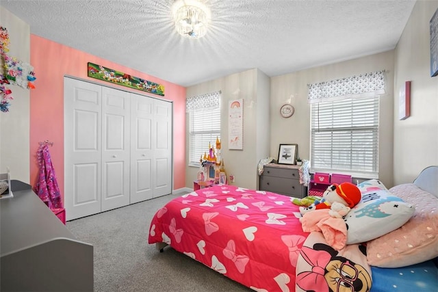 bedroom with a textured ceiling, carpet floors, multiple windows, and a closet