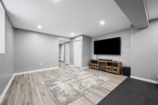 unfurnished living room featuring baseboards, recessed lighting, and wood finished floors