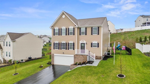 view of front of home with a front yard, central AC unit, aphalt driveway, an attached garage, and fence