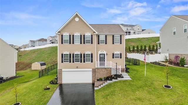 view of front of property with fence, a front lawn, driveway, and an attached garage