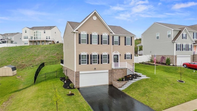view of front of home featuring a front lawn, a residential view, driveway, and an attached garage