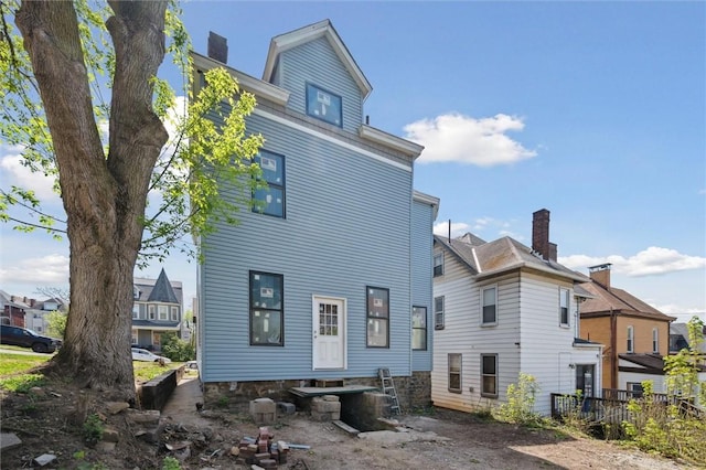 back of property with a chimney