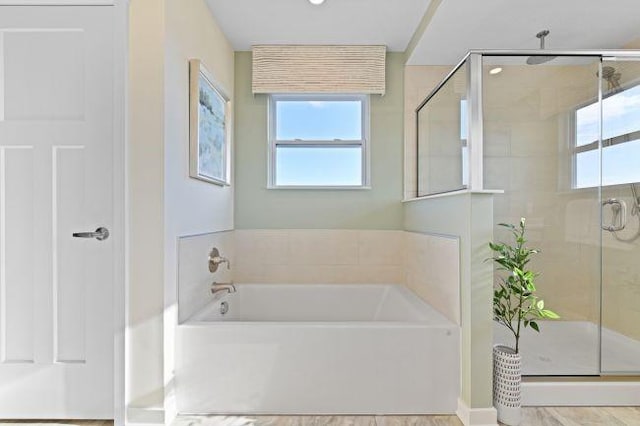 full bathroom with a shower stall, plenty of natural light, and a bath
