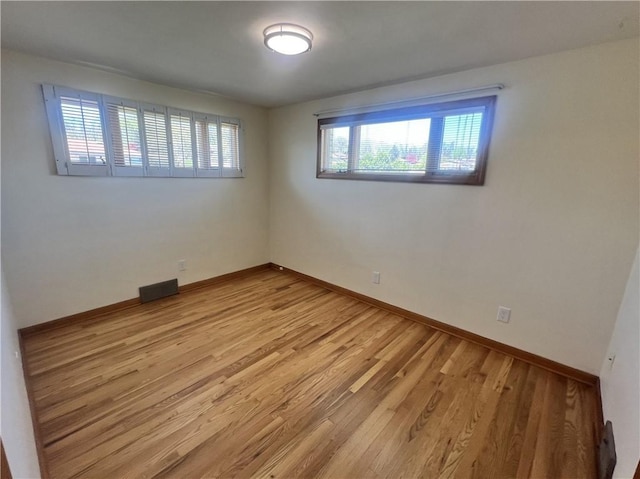 empty room with light wood finished floors and baseboards
