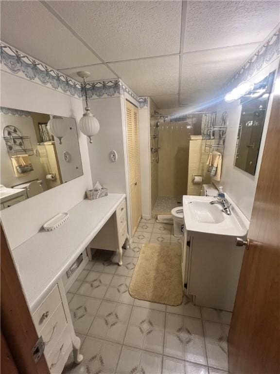 bathroom with a textured ceiling, a stall shower, toilet, vanity, and marble finish floor