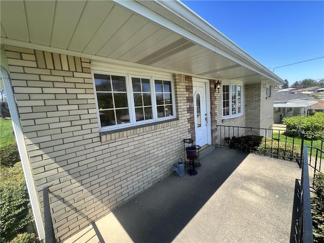 entrance to property featuring brick siding