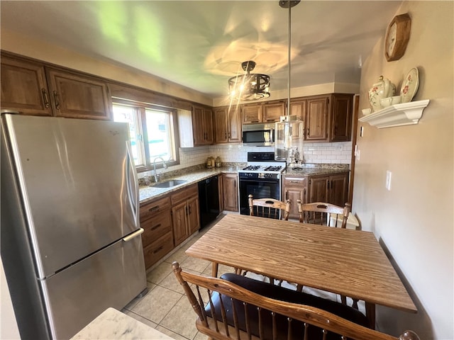 kitchen featuring stainless steel appliances, backsplash, a sink, pendant lighting, and light tile patterned flooring