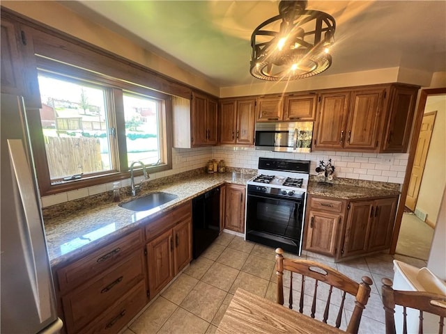 kitchen featuring tasteful backsplash, stainless steel microwave, dishwasher, a sink, and range with gas stovetop