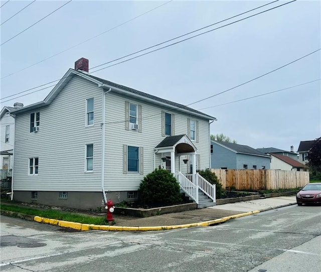 traditional-style house featuring fence and a chimney