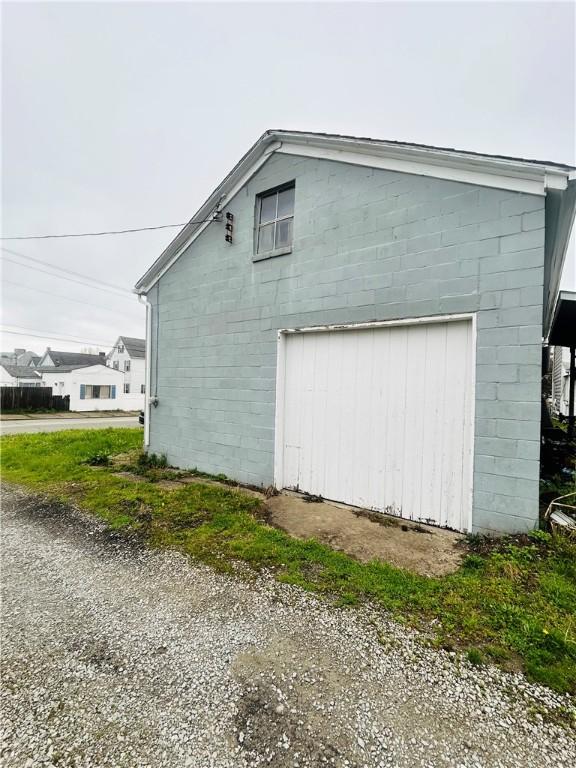 view of side of property with concrete block siding and a garage