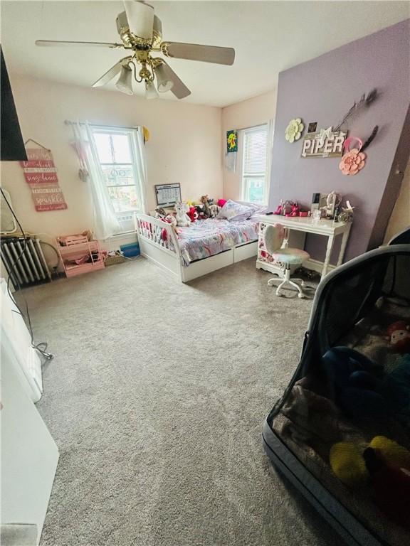 carpeted bedroom with a ceiling fan and multiple windows