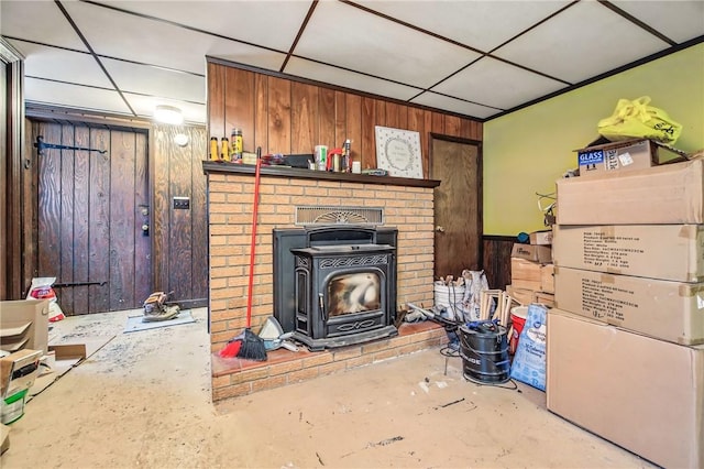 940 Fredonia Rd, Perry Twp Mer, PA 16130 - living area featuring a wood stove, wooden walls, concrete floors, and a paneled ceiling