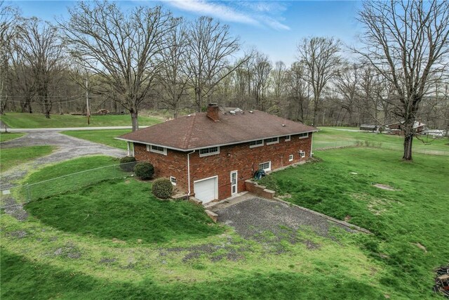 940 Fredonia Rd, Perry Twp Mer, PA 16130 - exterior space with a chimney, brick siding, a garage, driveway, and a lawn