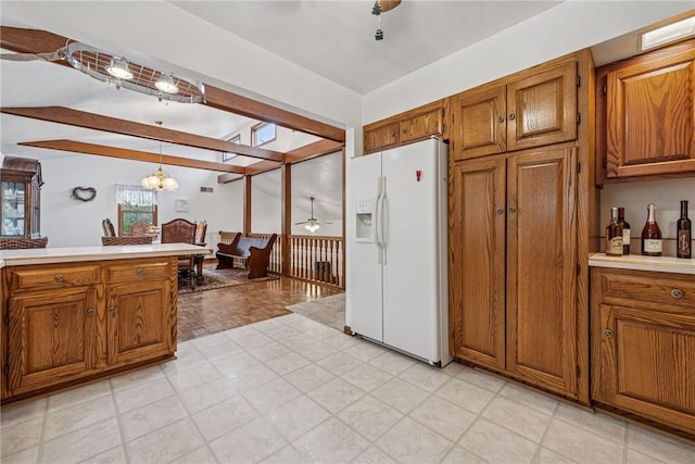 kitchen featuring white fridge with ice dispenser, brown cabinets, light countertops, and ceiling fan with notable chandelier