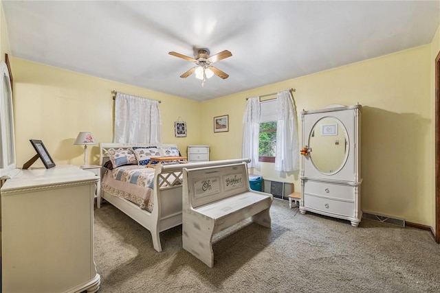 carpeted bedroom featuring a ceiling fan, visible vents, and baseboards