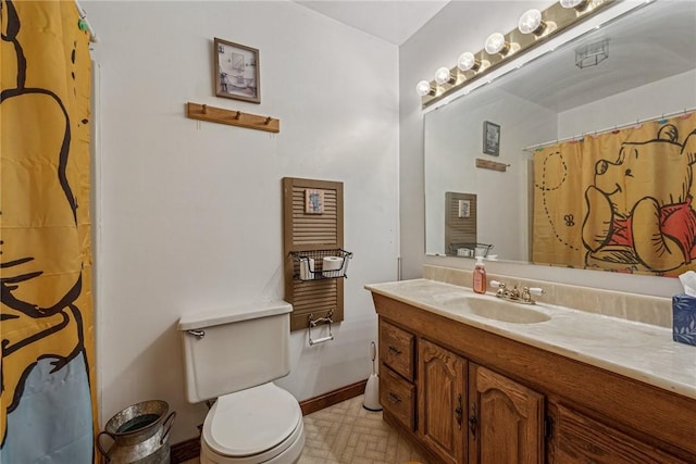 bathroom featuring toilet, a shower with shower curtain, vanity, and baseboards