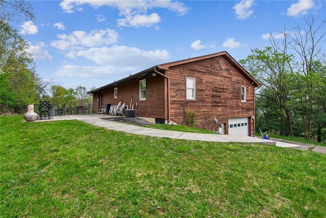 view of side of property featuring a lawn, central AC, a patio, and a garage