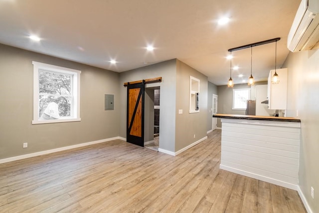 3052 Phelan Way, Polish Hill, PA 15219 - kitchen with a wall mounted air conditioner, freestanding refrigerator, a barn door, and baseboards