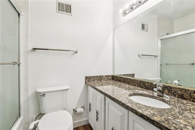 bathroom with vanity, toilet, and visible vents