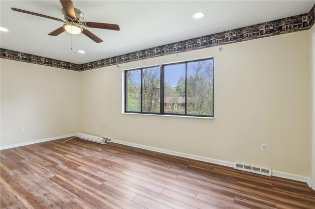 spare room featuring a ceiling fan, visible vents, wood finished floors, baseboards, and recessed lighting