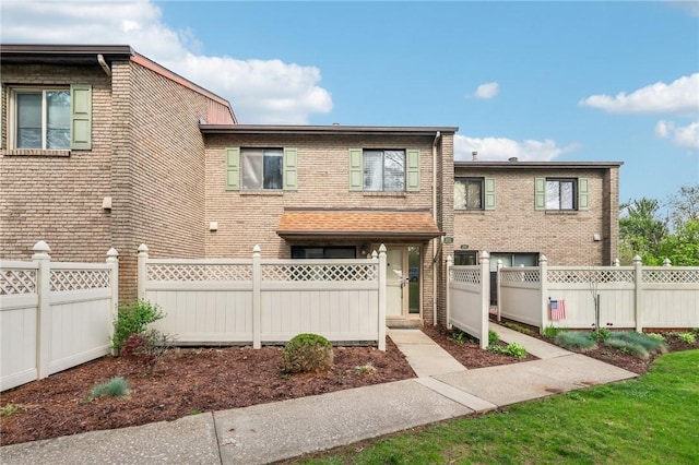 view of front of house featuring a fenced front yard and brick siding
