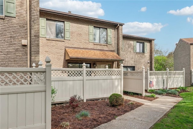 view of home's exterior with brick siding and fence