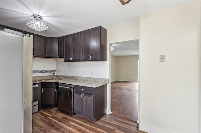 kitchen with dark brown cabinets, baseboards, dark wood-type flooring, a sink, and appliances with stainless steel finishes