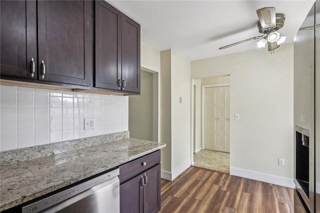 kitchen with backsplash, baseboards, a ceiling fan, dark wood-type flooring, and stainless steel dishwasher