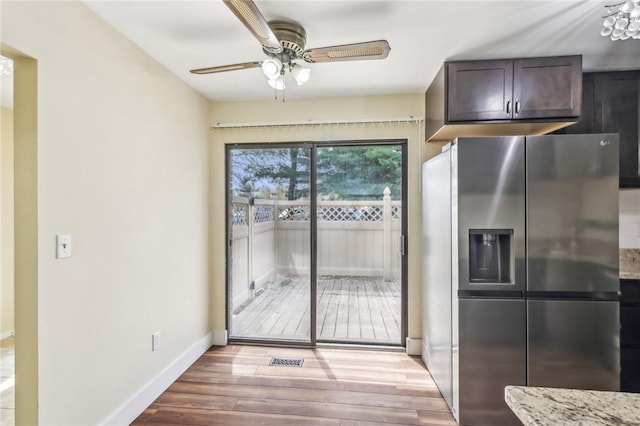 kitchen featuring dark brown cabinets, baseboards, stainless steel refrigerator with ice dispenser, a ceiling fan, and light wood finished floors