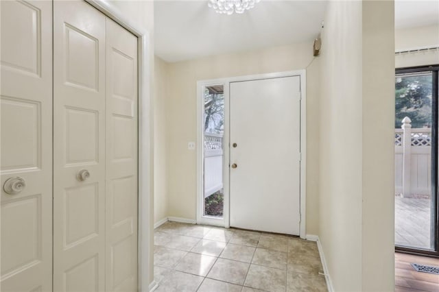 entryway featuring baseboards, light tile patterned flooring, and visible vents