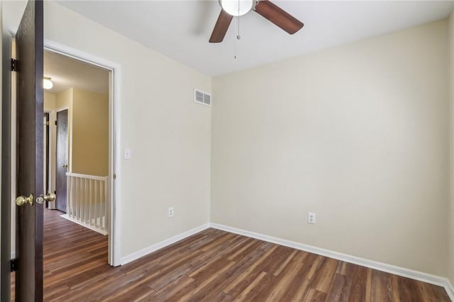 unfurnished room featuring dark wood-type flooring, baseboards, ceiling fan, and visible vents