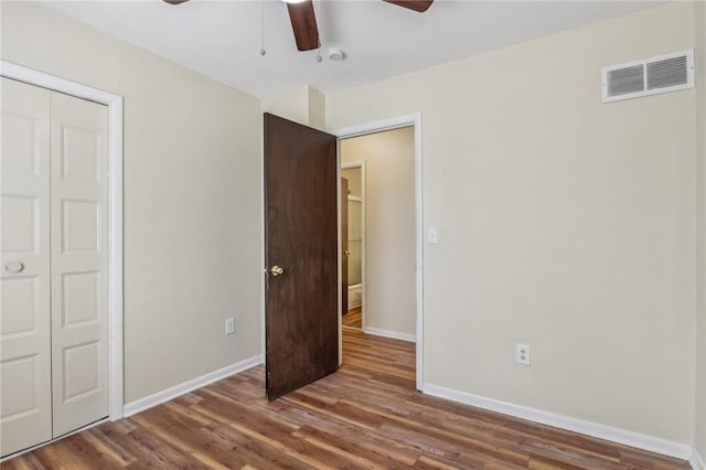 unfurnished bedroom with ceiling fan, baseboards, visible vents, and wood finished floors