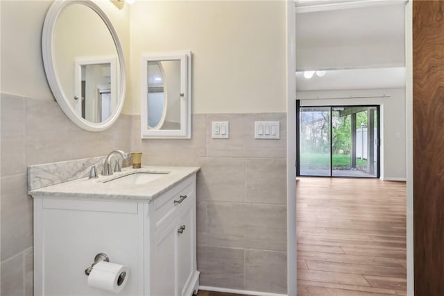 bathroom featuring tile walls, vanity, and wood finished floors